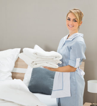 woman carrying a pile of sheets