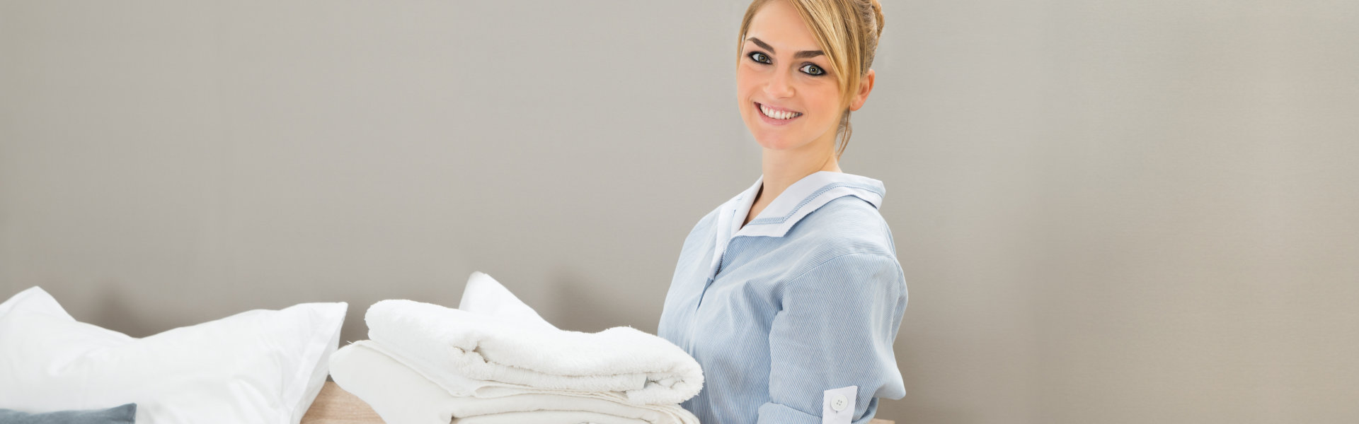 woman carrying a pile of sheets